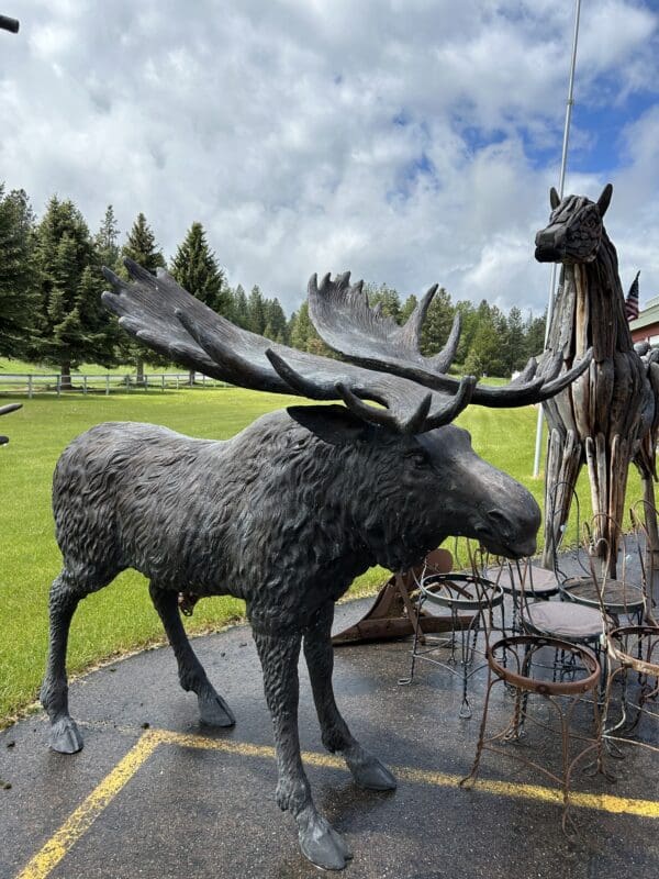 A moose statue in the middle of a park.