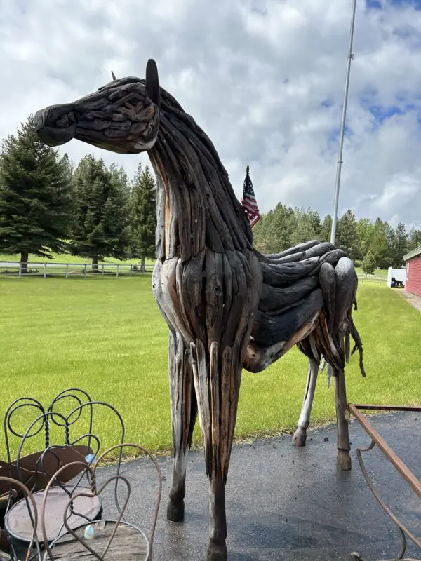 A horse statue made of wood and wire.