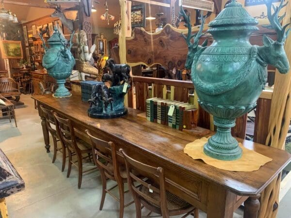 A long wooden table with many green vases on top of it.