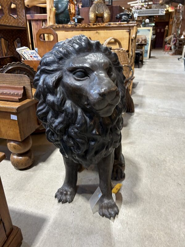 A statue of a lion sitting on the ground.