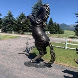 A statue of a horse is on the side walk