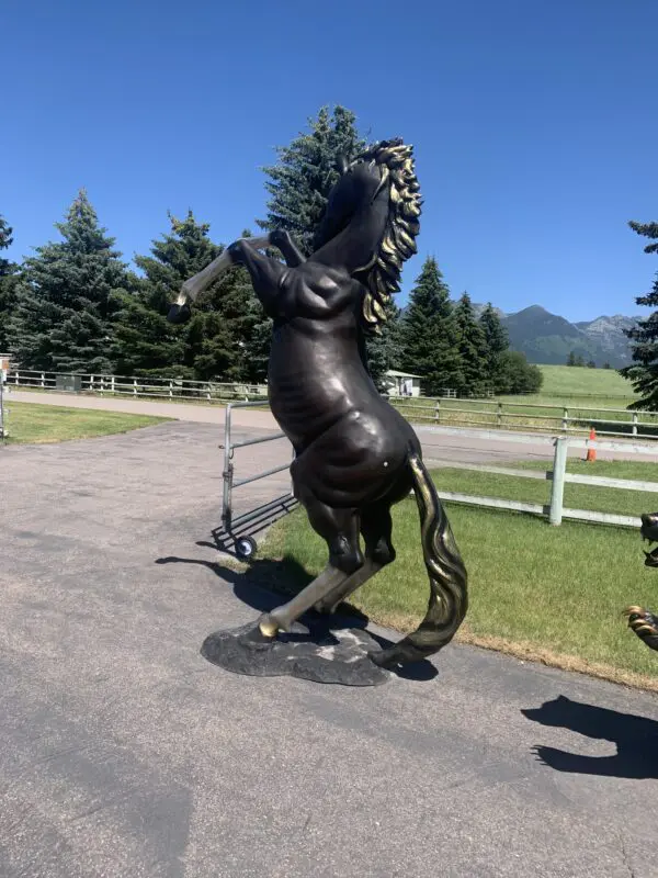 A statue of a horse is on the side walk