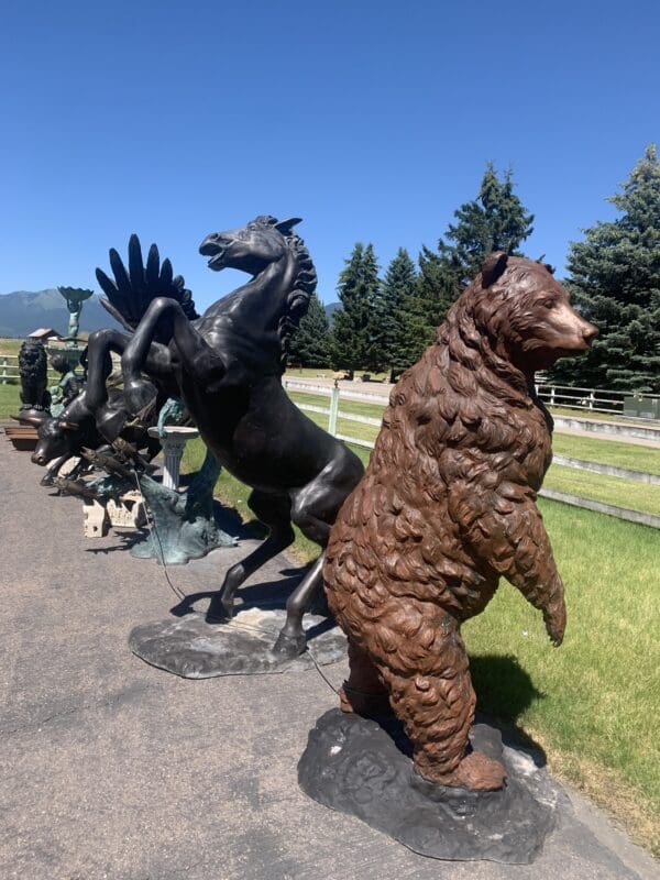 A row of statues of horses, bears and people.