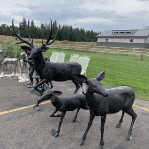 A group of deer statues on the ground.