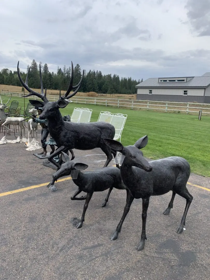 A group of deer statues on the ground.