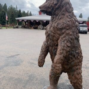 A bear statue in the middle of a parking lot.