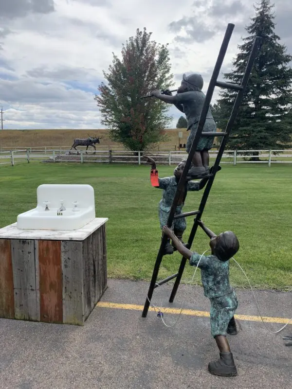 A boy and a monkey climbing on the ladder of a horse.